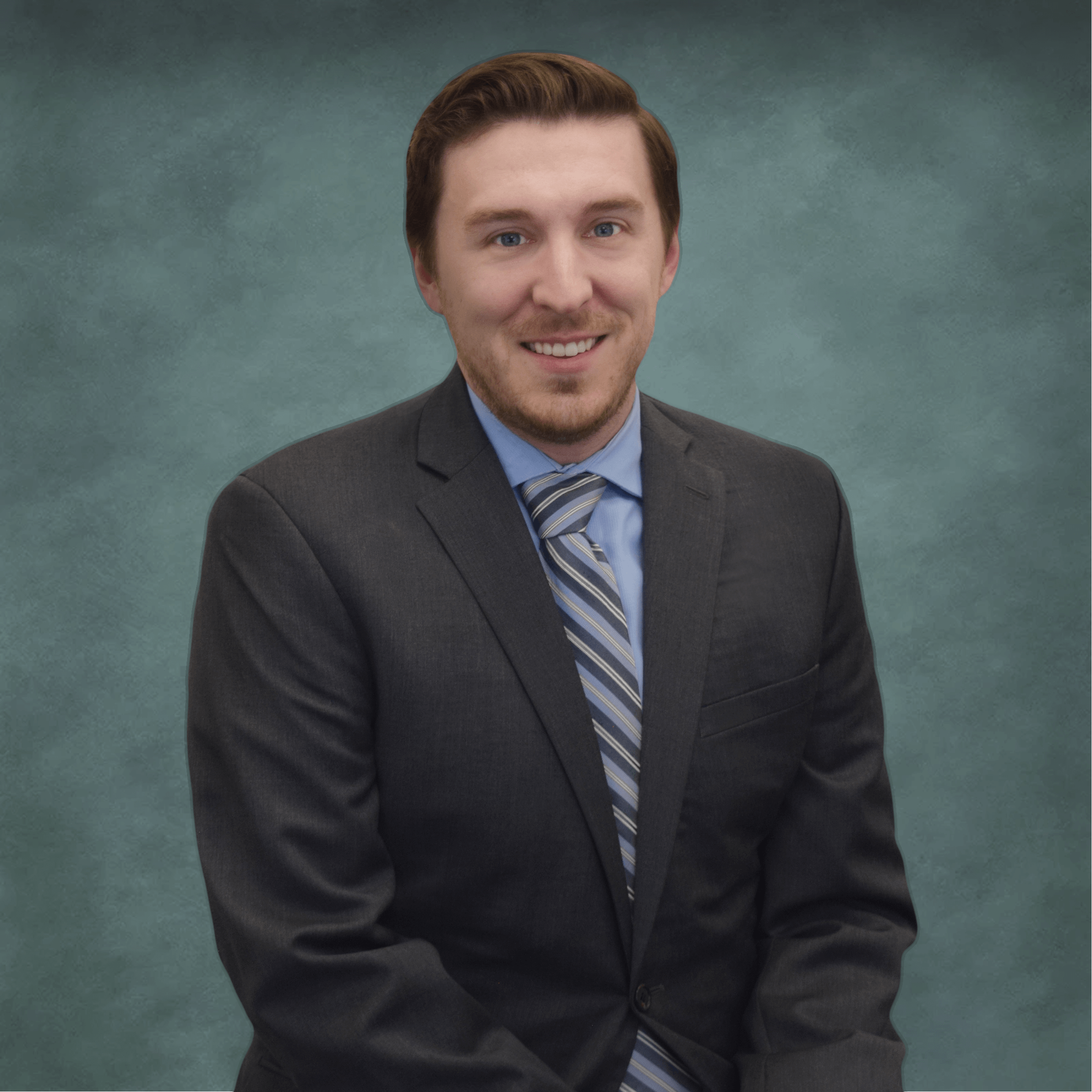 A professional headshot of Dr. Kyle Kram, an optometrist at Poudre Valley Eyecare, wearing a dark suit and striped tie against a greenish-grey background.